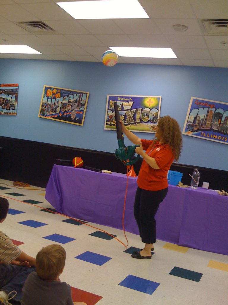 Woman blowing balloon with leaf blower